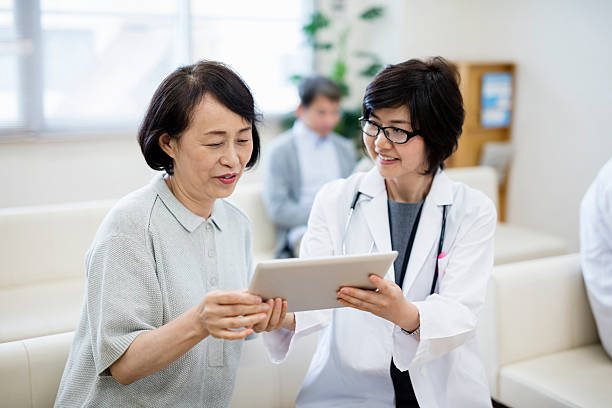 female doctor showing digital tablet to patient in hospital